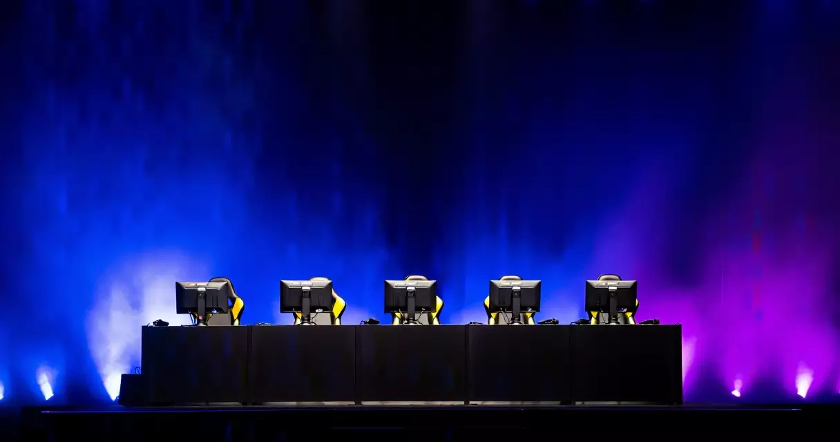 Empty esports stage with gaming chairs under dramatic blue and purple lighting