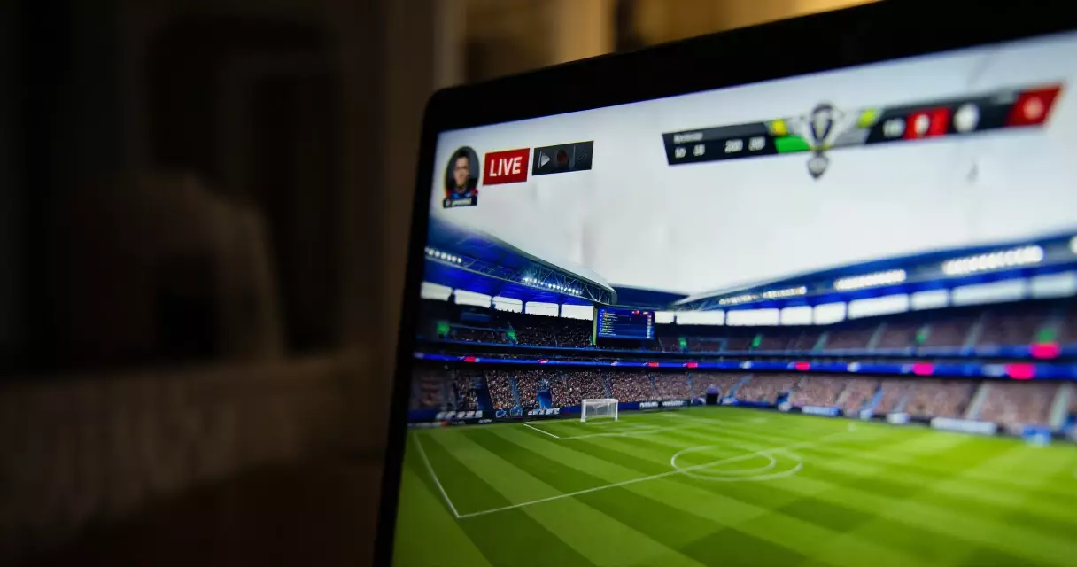 Live esports tournament broadcast on laptop screen with stadium crowd