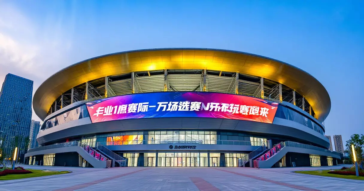 Modern multi-purpose arena exterior with esports event branding at dusk