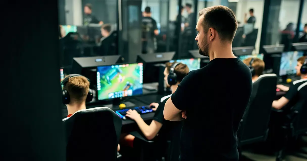 Esports coach observing players during a team practice session at a professional gaming facility