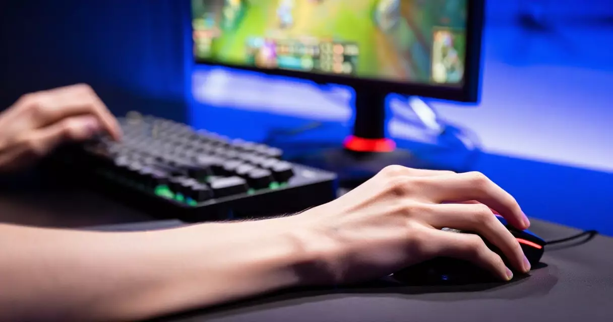 Professional League of Legends player at keyboard and mouse during tournament match