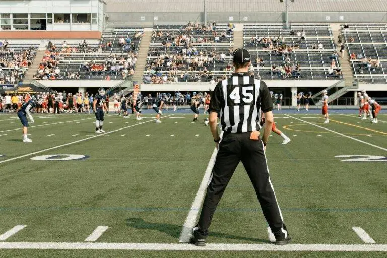 American football game with referee and players in action at a stadium in Toronto, Canada.